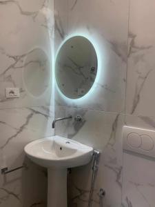 Un baño blanco con lavabo y espejo. en Guesthouse Sueda, en Ksamil