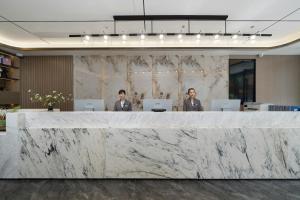 two men in an office with a marble reception counter at Echic Hotel in Guangzhou