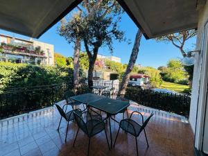 a patio with a table and chairs on a balcony at Charming Posillipo Sea View Ibiscus House in Naples