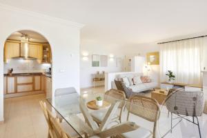 ein Wohnzimmer mit einem Glastisch und Stühlen in der Unterkunft La Manga Club Resort - Los Olivos 130 in Atamaría