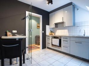a kitchen with white cabinets and a glass door at Altstadtflair Beim Schappeler in Memmingen
