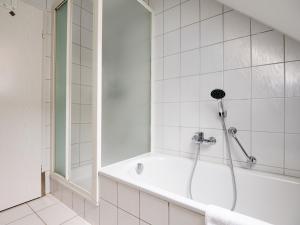 a white bathroom with a tub and a shower at Altstadtflair Beim Schappeler in Memmingen +7 photos