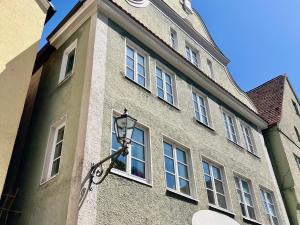 a building with a clock tower with a street light at Altstadtflair Beim Schappeler in Memmingen