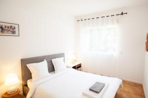 Un dormitorio blanco con una cama y una ventana. en Jardin d'Ivandry Piscine et terrasse, en Antananarivo