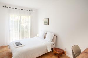 Un dormitorio blanco con una cama y una ventana. en Jardin d'Ivandry Piscine et terrasse, en Antananarivo 16 fotos más