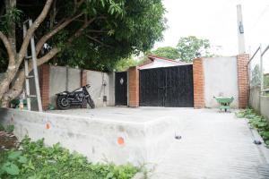 a motorcycle parked in a driveway with a fence at The Getaway Bailen in General Emilio Aguinaldo +7 photos
