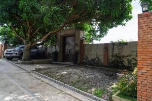 a house with a tree in front of a door at The Getaway Bailen in General Emilio Aguinaldo