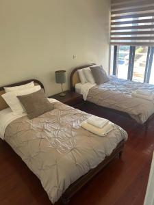 two beds sitting next to each other in a room at Apartamento Ruy Belo - Foz in Vila do Conde +6 photos