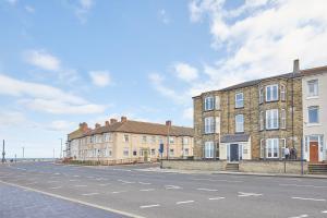 una calle vacía con una fila de edificios de ladrillo en Glenholme Apartments with Sea Views and Balconies in Redcar North Yorkshire, en Redcar
