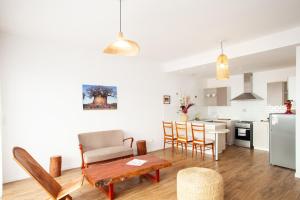 Una cocina y una sala de estar con mesa y sillas. en Jardin d'Ivandry Piscine et terrasse, en Antananarivo