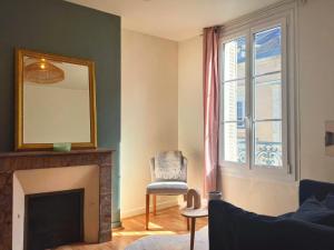 een woonkamer met een open haard en een spiegel bij Le Marceau in Angers +5 foto's