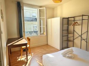 een kleine kamer met een bureau, een bed en een raam bij Le Marceau in Angers