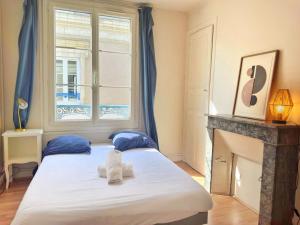 een slaapkamer met een groot bed en een open haard bij Le Marceau in Angers