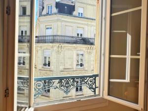 een raam met uitzicht op een gebouw bij Le Marceau in Angers