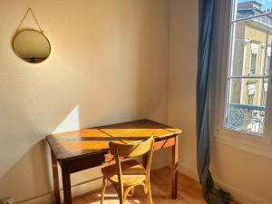 een eettafel met twee stoelen en een raam bij Le Marceau in Angers