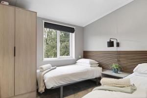 a bedroom with two beds and a window at Modern Lodge nr Ilfracombe & Beaches in West Down
