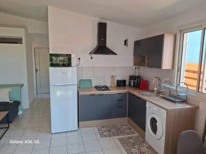 a kitchen with a white refrigerator and a dishwasher at Ti kaz Orion in Les Avirons