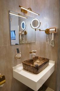 a bathroom with a stone sink and a mirror at Le Aura Grand Hotel in Lahore +34 photos