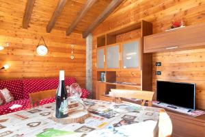 a dining room with a table with a bottle of wine at Maison du coeur - Bien-être in Challand Saint Anselme