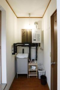 a kitchen with a sink and a microwave at ひだまりの宿 まゆしょう in Omachi