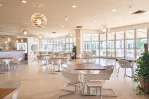 アルゲーロにあるBaia di Conteのテーブルと椅子と窓のあるレストラン +132枚の写真