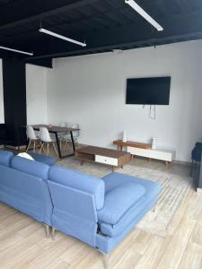 a living room with a blue couch and a flat screen tv at Departamento con 3 habitaciones en Torre Palmas in Tijuana