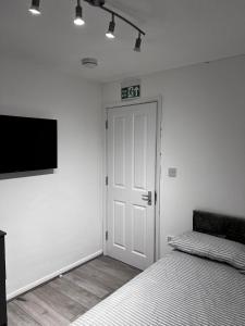 a bedroom with a bed and a door and a tv at Lovely Double Room available, in shared house in London