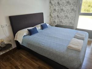 a bedroom with a large bed with blue pillows at Apartamentos Parke24 San Sebastian by RUVA in Rentería