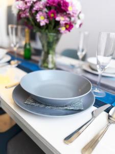 a plate on a table with a vase of flowers at Wohnung Bernstein in Burgtiefe auf Fehmarn 