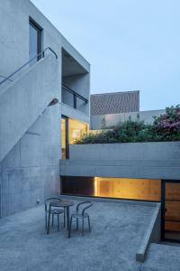 生駒市にあるOne Floor Designed by Architect Tadao Andoの椅子2脚とテーブル1台のあるコンクリートの家