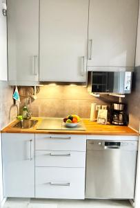 a kitchen with white cabinets and a bowl of fruit on the counter at Wohnung Bernstein in Burgtiefe auf Fehmarn 