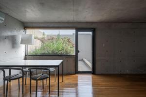 生駒市にあるOne Floor Designed by Architect Tadao Andoのテーブルと椅子と窓のあるダイニングルーム