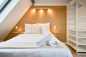 ein Schlafzimmer mit einem großen Bett mit weißen Regalen in der Unterkunft Studio mansardé à deux pas de la Citadelle in Lille