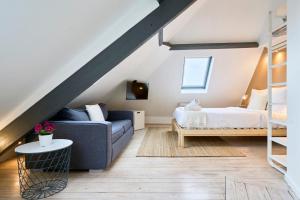 ein Wohnzimmer mit einem Bett und einer Couch in der Unterkunft Studio mansardé à deux pas de la Citadelle in Lille