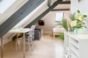 ein Wohnzimmer mit Tisch und ein Schlafzimmer in der Unterkunft Studio mansardé à deux pas de la Citadelle in Lille + 14 Fotos