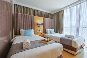 a hotel room with two beds and a window at Empire Suites Subang by MyKey in Subang Jaya