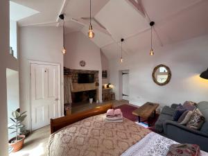 a bedroom with a bed and a living room at Cosy Northumberland Studio Cottage in Thropton