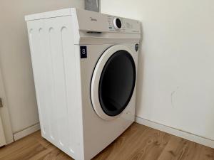 a white washing machine in a corner of a room at 2-Bedroom Stylish Apartment with Free Parking in Vienna