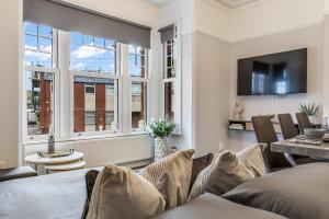 a living room with a couch and a window at The Grand Edwardian 3 Bedroom Apartment in Edgware