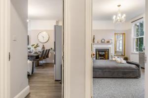a bedroom with a bed and a clock on the wall at The Grand Victorian 3 Bedroom Apartment in Edgware