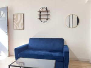 a blue couch in a living room with a table at Le Beige in Le Mans +2 photos