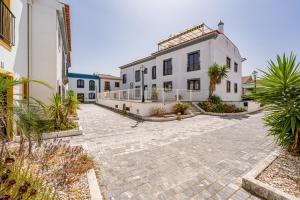 une cour d'un bâtiment blanc avec des plantes dans l'établissement Alentejo Bliss Your Cozy Getaway, à Mourão