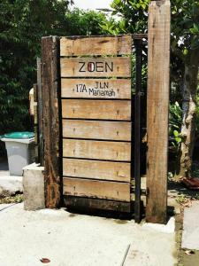 Una valla de madera con un cartel que dice zen istg en A Borneo Guesthouse, en Johor Bahru