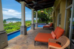 Un patio con sillas y una mesa y vista al agua. en Villa Angel 4 bdr Ocean View pool in Los Suenos, en Isla Herradura
