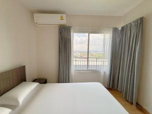 Un dormitorio con una cama y una ventana grande. en 芭提雅市中心大空间公寓酒店预定 城景健身房泳池舒适型公寓 日租周租月租灵活, en Pattaya South 21 fotos más