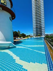 una piscina junto a un edificio alto en 芭提雅市中心大空间公寓酒店预定 城景健身房泳池舒适型公寓 日租周租月租灵活, en Pattaya South