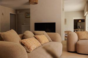 a living room with two chairs and a couch at Villa La Perle in Talmont