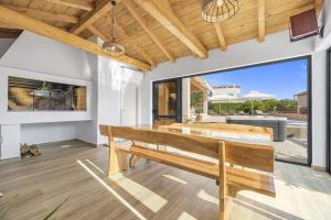 a dining room with a wooden bench and a patio at Villa Kunfin ZadarVillas in Bibinje