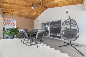 a room with a table and chairs and a bird cage at Villa Kunfin ZadarVillas in Bibinje +46 photos