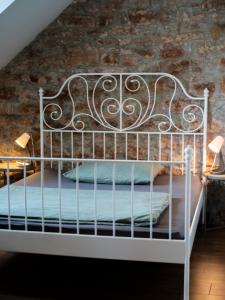 a white bed in a room with a brick wall at Modern stone house in Balatonfüred with jacuzzi in Balatonfüred